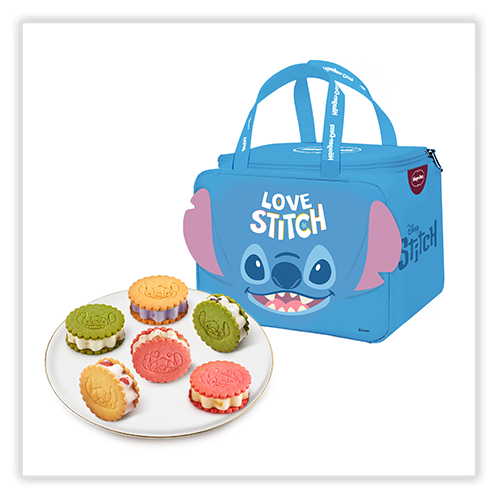 A blue lunch bag with a design of Stitch from Disney's "Lilo & Stitch" and the text "LOVE STITCH" on the front, featuring two handles and a zipper closure. Beside the bag is a white plate holding six colorful sandwich cookies in green, yellow, red, and pink, each with unique designs.